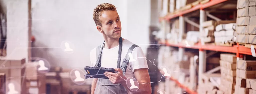 Homem em um armazém, utilizando um dispositivo portátil para gerenciar o estoque, com ícones de pessoas ao redor, simbolizando a gestão logística e o fluxo de informações.
