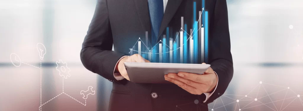Profissional de terno analisa gráficos de crescimento projetados digitalmente em um tablet, ilustrando a gestão data-driven e o uso de inteligência artificial nos negócios.