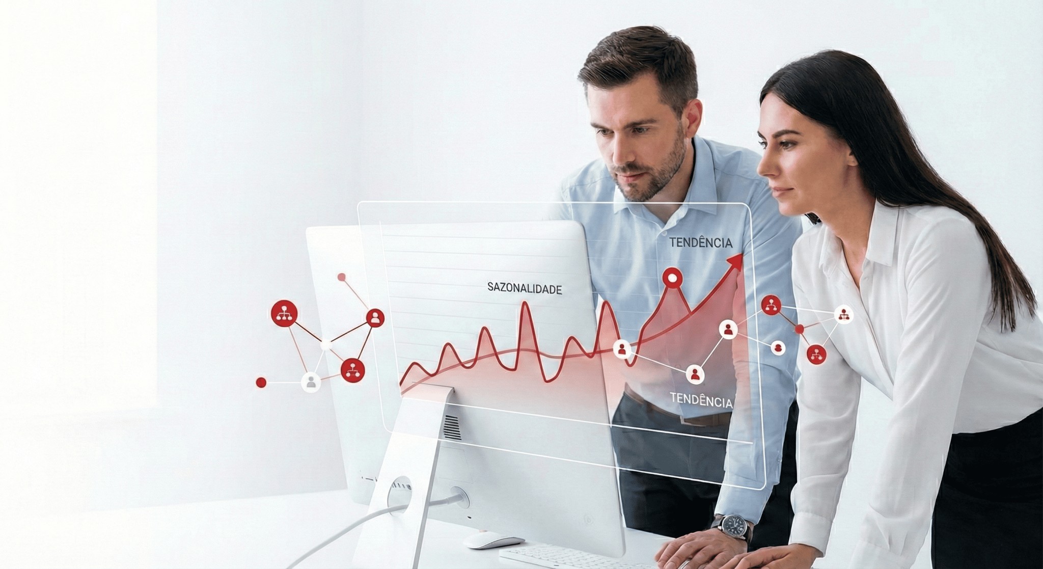 Dois profissionais analisando gráfico de previsão de demanda com sazonalidade e tendência em monitor.