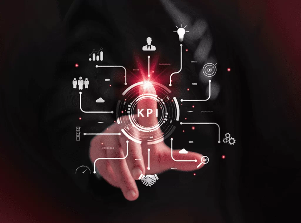 Mão interagindo com um painel digital com a sigla "KPI" em destaque e diversos ícones conectados, representando a medição do sucesso de soluções de inteligência artificial através de indicadores de desempenho (KPIs). Capa do artigo sobre a importância dos KPIs para avaliar a eficácia da IA.