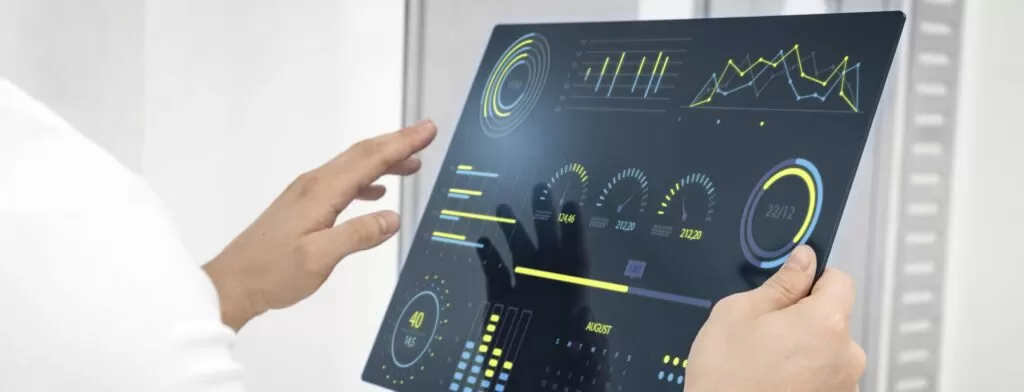 Mãos segurando tablet digital com gráficos e dados, representando a análise inteligente de leads proporcionada pela inteligência artificial, o que acaba gerando uma melhora na qualidade do funil.