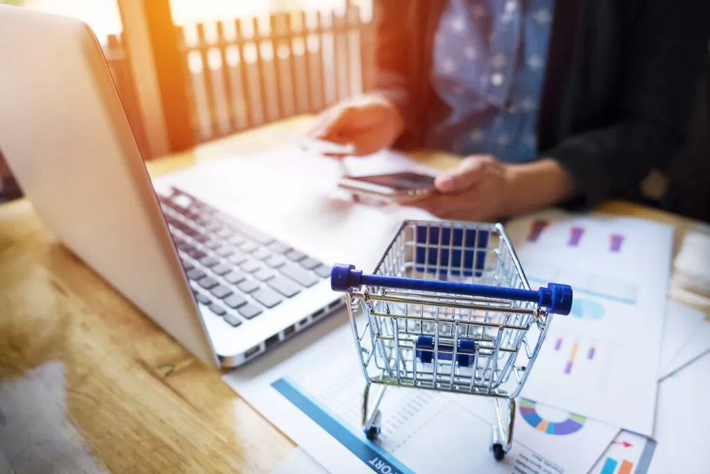 Mulher fazendo uma compra online no notebook, representando a oportunidade de venda para empresas que analisam o risco e decidem participar da Black Friday.