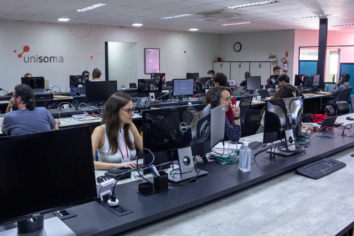 Vista do escritório aberto da UniSoma em Campinas, com estações de trabalho